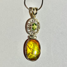 Load image into Gallery viewer, Ammolite pendant in Sterling Silver with Peridot.   Shifting colours, yellow, green, orange sparkle.