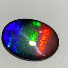 Load image into Gallery viewer, AAA+ ammolite calibrated cabochon. Beautiful flash red, green and blue colours. 25x18 mm low dome quartz cap