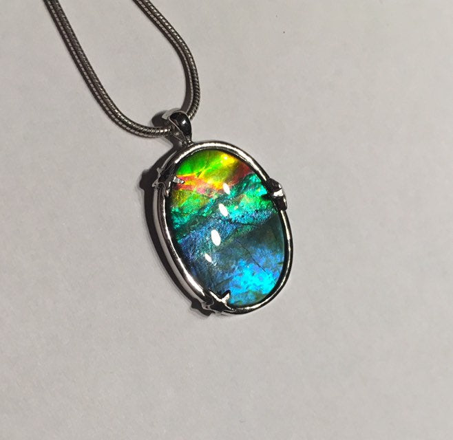 Ammolite pendant in Sterling silver setting with small starfish holding the stone in place. Amazing colour and lustre.