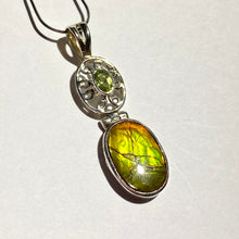 Load image into Gallery viewer, Ammolite pendant in Sterling Silver with Peridot.   Shifting colours, yellow, green, orange sparkle.
