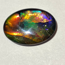 Load image into Gallery viewer, AAA+ ammolite calibrated cabochon. Exceptional colours and depth in this beautiful stone with pink and purple. 25x19 mm low dome quartz cap
