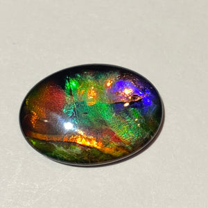 AAA+ ammolite calibrated cabochon. Exceptional colours and depth in this beautiful stone with pink and purple. 25x19 mm low dome quartz cap